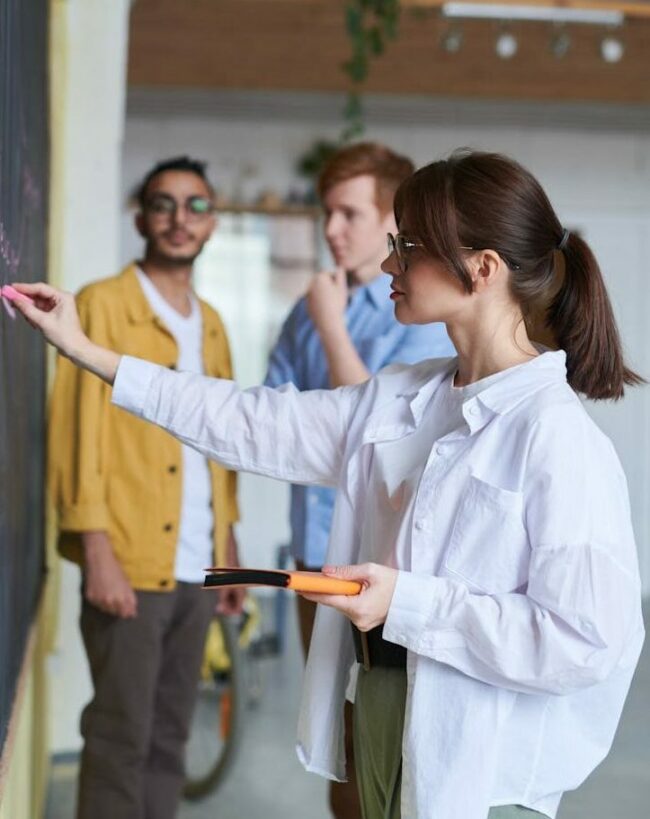 Photo Of Woman Writing On Blackboard